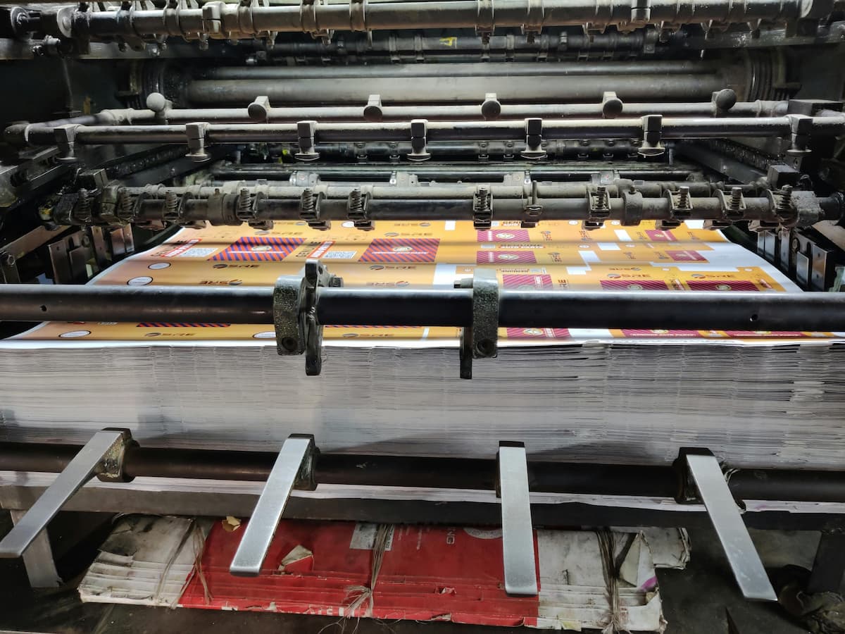Offset printer printing a stack of printed marketing materials