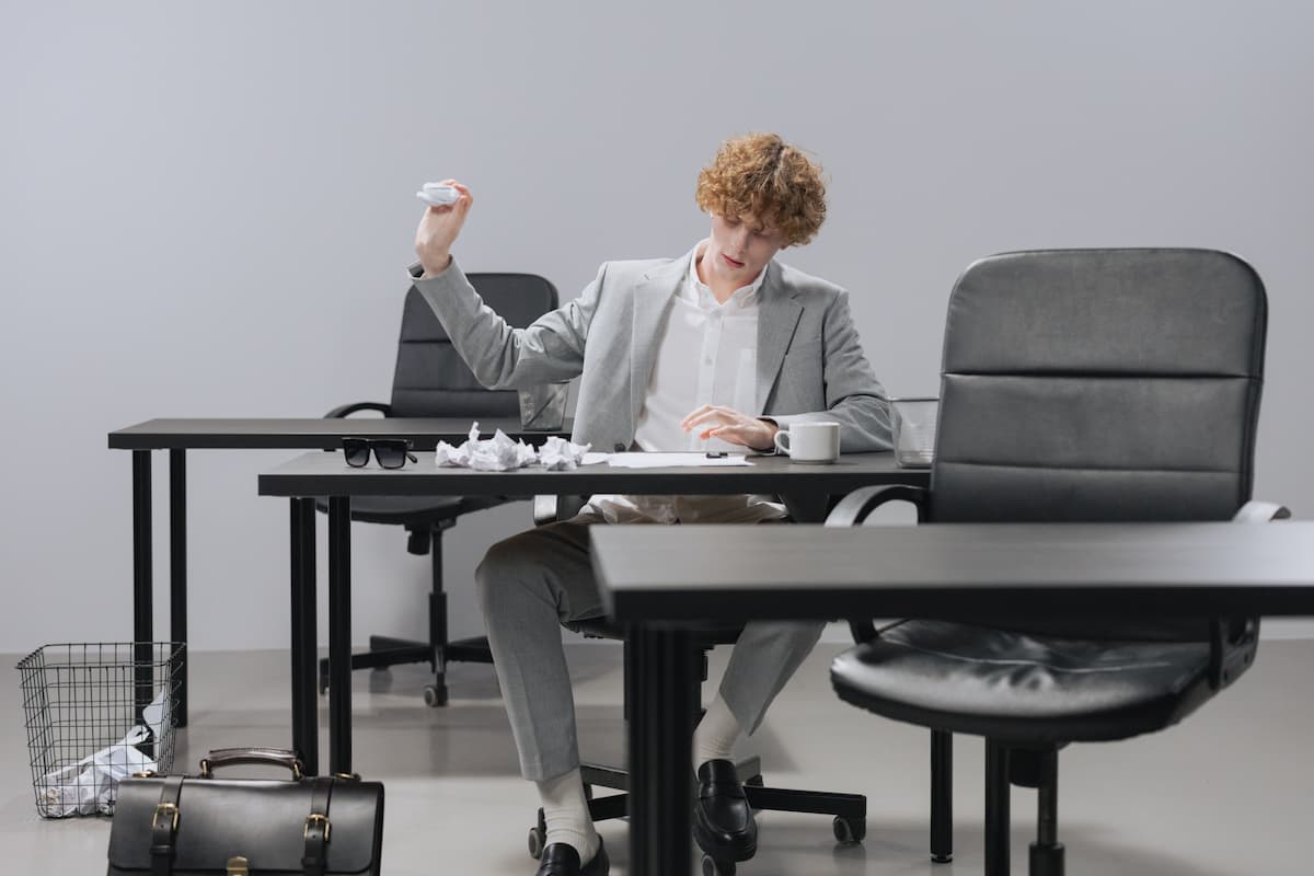 Man crumpling up papers and prints with mistakes