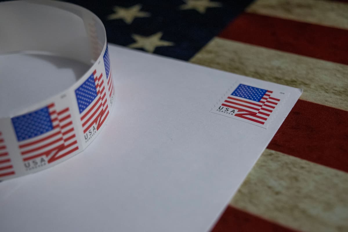 Mail with USA Forever stamp with a roll of stamps sitting on top of it